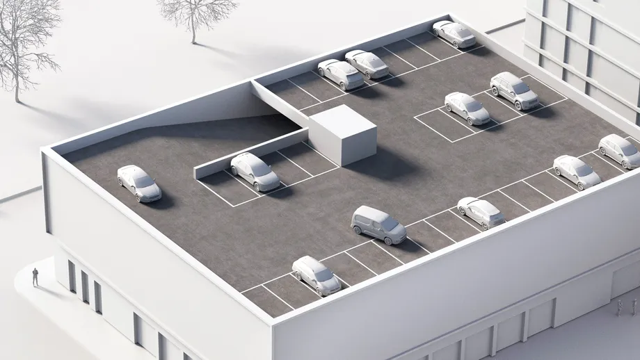 En hvid arkitekturmodel af en bygning med et parkeringsdæk på øverste etage